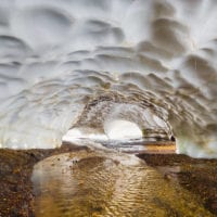 Höhle unter einem Schneefeld, Bach, Landmannalaugar, Island